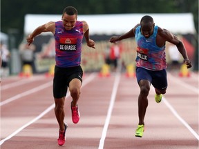 Andre De Grasse, left, of Markham, Ont., powers over the finish line to win gold in the men's 100-metre race of the Canadian Track and Field Championships at the Terry Fox Athletic Facility on Friday. Gavin Smellie, right, of Brampton, Ont., finished third. THE CANADIAN PRESS/Fred Chartrand