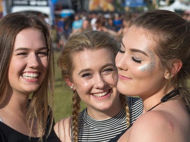 Sydney Ippolito, 17, (from left), Byanna Kuhn, 17, and Heather Mackie, 17, with her glitter on for the artist Migos as day seven of the RBC Bluesfest takes place on the grounds of the Canadian War Museum.