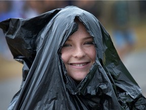 Grace Hawkin uses a garbage bag to stay dry as day five of the RBC Bluesfest takes place on the grounds of the Canadian War Museum.