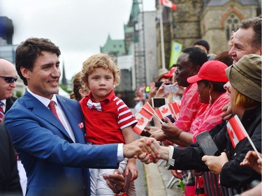 Prime Minister Justin Trudeau and his son Hadrien, greet people during Canada 150 celebrations in Ottawa on Saturday, July 1, 2017.