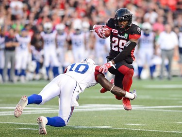 Ottawa Redblacks running back William Powell (29) is tackled by Montreal Alouettes linebacker Chris Ackie (10) during first half CFL football action in Ottawa on Wednesday, July 19, 2017.