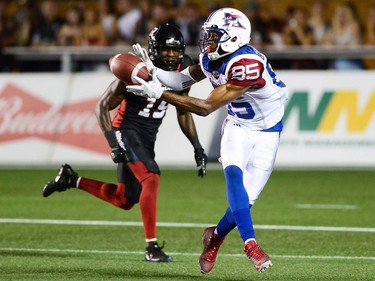 Montreal Alouettes wide receiver B.J. Cunningham (85) makes a catch in front of Ottawa Redblacks defensive back Imoan Claiborne (19) during second half CFL football action in Ottawa on Wednesday, July 19, 2017.