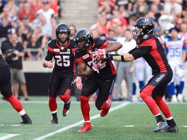 Ottawa Redblacks running back William Powell (29) takes a hand off from quarterback Trevor Harris (7) during first half CFL football action against the Montreal Alouettes in Ottawa on Wednesday, July 19, 2017.