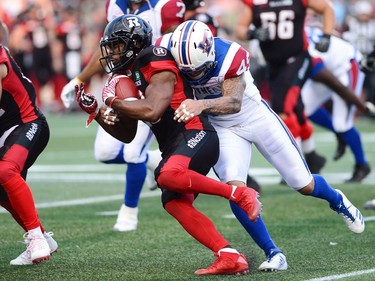 Ottawa Redblacks running back William Powell (29) is tackled by Montreal Alouettes linebacker Dominique Tovell (49) during first half CFL football action in Ottawa on Wednesday, July 19, 2017.