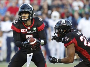 Ottawa Redblacks quarterback Trevor Harris (7) fakes handing the ball off to running back Mossis Madu Jr. (23) during the first half of Saturday's game against the Argonauts. THE CANADIAN PRESS/Patrick Doyle
