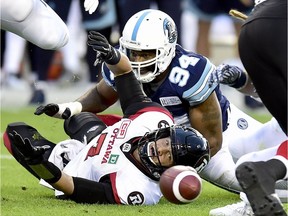 Ottawa Redblacks quarterback Trevor Harris (7) fumbles the ball as Toronto Argonauts defensive end Victor Butler (94) completes the tackle during first half CFL action in Toronto, Monday, July 24, 2017.