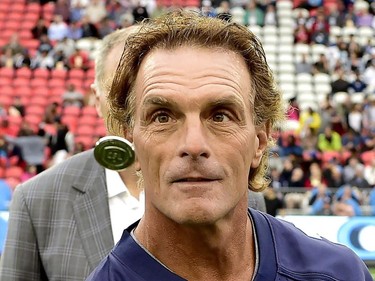 Former Argos player Doug Flutie keeps his eye on the ceremonial coin toss before first half CFL action in Toronto, Monday, July 24, 2017.