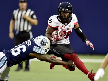 Ottawa Redblacks running back William Powell (29) evades a tackle attempt by Toronto Argonauts defensive back Cassius Vaughn (26) during first half CFL action in Toronto, Monday, July 24, 2017.