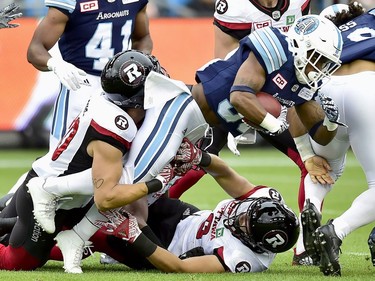 Toronto Argonauts running back Martese Jackson (30) gets taken down by Ottawa Redblacks defensive back Jean-Philippe Bolduc, left, during first half CFL action in Toronto, Monday, July 24, 2017.