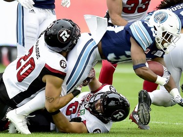 Toronto Argonauts running back Martese Jackson (30) gets taken down by Ottawa Redblacks defensive back Jean-Philippe Bolduc, left, during first half CFL action in Toronto, Monday, July 24, 2017.