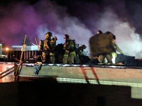 Ottawa firefighters on the roof of a three-alarm blaze at an Orléans school Tuesday morning.