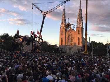 Crowds gather outside Notre Dame Cathedral on Thursday night awaiting the awakening of Kumo, the spider from La Machine. Julie Oliver/Postmedia