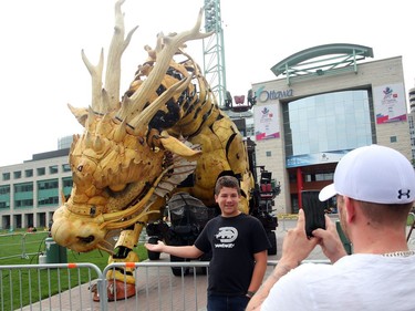 Malcom Willar of Ottawa, has his picture taken with the sleeping Long Ma, the dragon-horse, at the Ottawa City Hall, July 27, 2017.
