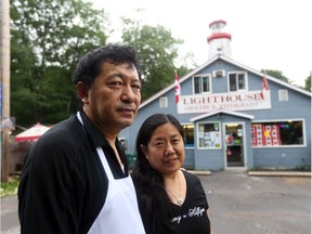 Sandy Zhang and husband and store owner Honggao Ji in front of their Constance Bay store and temporary home. The restaurant, back in business, suffered a two-week shutdown during the worst of the flood when water swirled around the building and filled the basement.