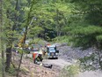 Crews at work reinforcing cliff walls and rebuilding a creek bed near Turnberry Road in Orléans.