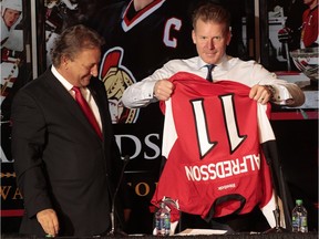 Owner Eugene Melnyk watches as Daniel Alfredsson puts on a jersey after signing a one-day contract so he could retire as a Senators player in December 2014. Tony Caldwell/Postmedia