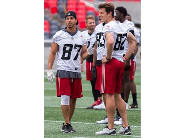 Receivers Joshua Stangby (L) and Greg Ellingson confer as the Ottawa Redblacks practice at TD Place.