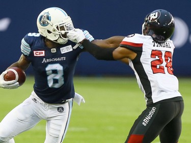 Jeff Fuller of the Toronto Argos gets a face mask from Corey Tindal of the Ottawa Redblacks at BMO field in Toronto during CFL action in Toronto, Ont. on Monday July 24, 2017.