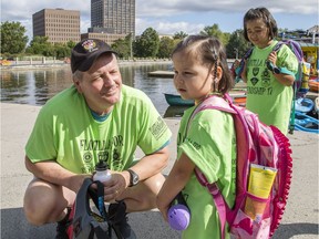 Ottawa police Sgt. Chris Hrnchiar, left, chats with four-year-old Napachie Pootoogook, centre, while Ellie, 8, look on at Dow's Lake during the 17th Flotilla for Friendship on Wednesday.