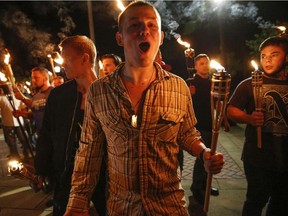 In this photo taken Friday, Aug. 11, 2017, multiple white nationalist groups march with torches through the UVA campus in Charlottesville, Va. Hundreds of people chanted, threw punches, hurled water bottles and unleashed chemical sprays on each other.