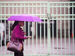 A woman walks under a colourful umbrella through the ByWard Market in Ottawa during a light downpour Friday, August 18, 2017. (Darren Brown/Postmedia)
Darren Brown, Postmedia