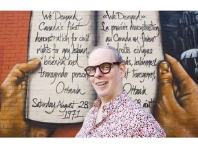 Glenn Crawford stands in front of a mural at the corner of Bank and Gilmour Street.