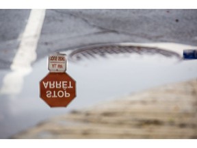 A stop sign is reflected in a puddle at the corner of Somerset St. W and The Driveway Monday, August 21, 2017.  (Darren Brown/Postmedia) Neg: 127364

127364
Darren Brown, Postmedia