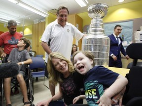 Pittsburgh Penguins coach Jacques Martin shows the Stanley Cup to Crosby, 4, at CHEO in Ottawa on Tuesday, August 22, 2017.