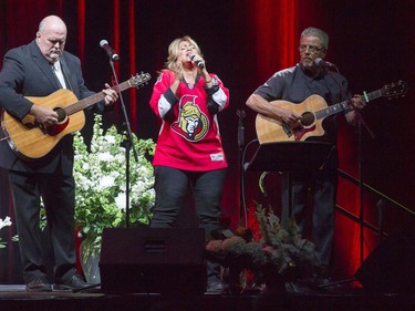 Gail Gavan, centre, sings during a celebration of life service for former Ottawa Senators general manager and coach, Bryan Murray, at the Canadian Tire Centre Thursday,