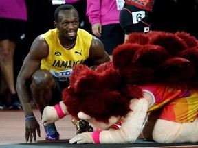 Jamaica&#039;s Usain Bolt smiles next to mascot Hero the Hedgehog after his men&#039;s 100m heat the World Athletics Championships in London Friday, Aug. 4, 2017. (AP Photo/Matthias Schrader)