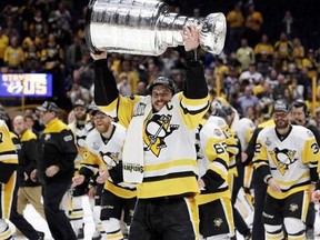 Pittsburgh Penguins&#039; Sidney Crosby (87) celebrates with the Stanley Cup after defeating the Nashville Predators in Game 6 of the NHL hockey Stanley Cup Final, in Nashville, Tenn., on Sunday, June 11, 2017. THE CANADIAN PRESS/AP-Mark Humphrey