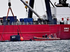The turret of sunken privately built and owned submarine submarine UC3 Nautilus is seen by the side of a salvage vessel during an operation taking place in connection with a criminal investigation, in Oeresund strait near Copenhagen, Denmark, Saturday, Aug. 12, 2017. Danish prosecutors urged a judge on Saturday to hold in pre-trial detention the owner of an amateur-built submarine, suspected of being responsible for the disappearance of a Swedish woman who had been onboard the ship that later sa