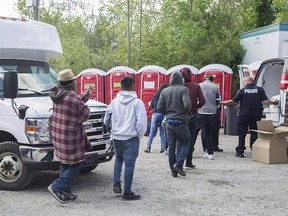 The Liberal government is misleading people when it says there&#039;s no advantage to crossing illegally into Canada to seek asylum, NDP MP Jenny Kwan says. Asylum seekers line up to receive boxed lunches after entering Canada from the United States at Roxham Road in Hemmingford, Que., Wednesday, August 9, 2017. THE CANADIAN PRESS/Graham Hughes