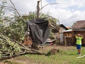 Emile Turcotte looks at his trampoline hanging from a tree as a result of a category one tornado, Wednesday, August 23, 2017 in Lachute, Que., northwest of Montreal.THE CANADIAN PRESS/Ryan Remiorz