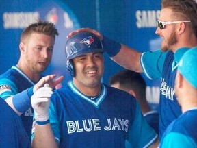 Toronto Blue Jays&#039; Kendrys Morales, left, is congratulated by teammates in the dugout after hitting a solo home run against the Minnesota Twins during second inning American League MLB baseball action in Toronto on Saturday, August 26 2017. THE CANADIAN PRESS/Chris Young