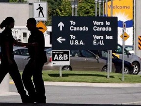 Canadian border guards are silhouetted as they replace each other at an inspection booth at the Douglas border crossing on the Canada-USA border in Surrey, B.C., on Thursday, August 20, 2009. Canada&#039;s border agency has quietly begun sharing information with U.S. Homeland Security about the thousands of American citizens who cross into Canada each day. THE CANADIAN PRESS/Darryl Dyck