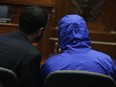 In this July 31, 2014 file photo, a Syrian Army defector (blue hooded jacket) who smuggled 50,000 photographs out of Syria documenting the torture and execution of more than 10,000 dissidents, listens to an interpreter during a briefing before the House Foreign Affairs Committee on Capitol Hill in Washington. A paper trail, the authors say, mean there could be justice found for Syria's dead and tortured. (Alex Wong, Getty Images)
