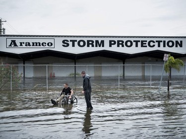 Brad Matheney offers help to a man in a wheelchair in a flooded street while Hurricane Henry passes through Texas August 26, 2017 in Galveston, Texas. Hurricane Harvey left a trail of devastation Saturday after the most powerful storm to hit the US mainland in over a decade slammed into Texas, destroying homes, severing power supplies and forcing tens of thousands of residents to flee.