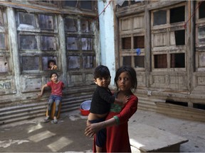 A girl hold her sister as she poses for a photograph in the old city of Kabul, Afghanistan, Wednesday, Aug. 16, 2017.