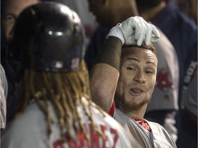 Boston's Christian Vazquez, right, is congratulated in the dugout after hitting a two-run homer off Toronto relief pitcher Danny Barnes in the seventh inning on Monday night. THE CANADIAN PRESS/Chris Young