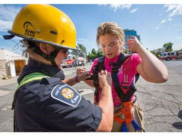 Firefighter Dana Best (L) helps Savanna Cleveland with her harness as the week long Camp FFIT continues at the Ottawa Fire Services Training Centre.