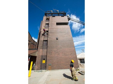 Firefighter Dana Best (R) looks on as Abby Emom rappels down the tower as the week long Camp FFIT continues at the Ottawa Fire Services Training Centre.