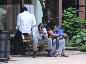 A group of asylum seekers sit outside the front entrance of the Nav Centre.