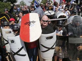 White nationalist demonstrators use shields as they guard the entrance to Lee Park in Charlottesville, Va., Saturday, Aug. 12, 2017. (AP Photo/Steve Helber) ORG XMIT: VASH304

SATURDAY, AUG. 12, 2017 PHOTO
Steve Helber, AP