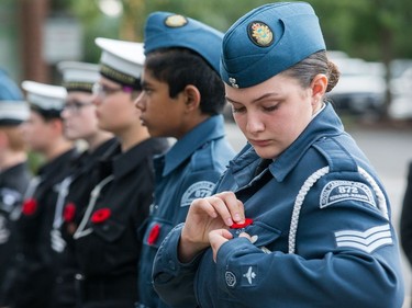 Air Cadet Sgt Amanda Patterson pins a poppy on her uniform as the 75th Anniversary of Dieppe Sunset Ceremony takes place at the Kanata Legion Cenotaph.