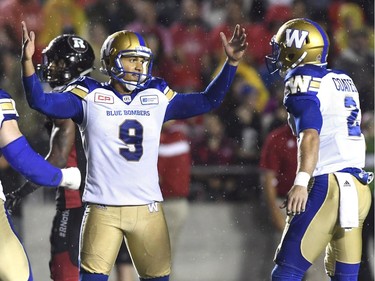 Blue Bombers kicker Justin Medlock (9) raises his hands as he celebrates his game-winning field goal with teammate Matt Coates (2). THE CANADIAN PRESS/Justin Tang