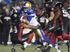 Redblacks linebacker Taylor Reed (44) makes one of his four tackles in Friday's game against Blue Bombers quarterback Matt Nichols during the second half of play at TD Place stadium on Friday night. THE CANADIAN PRESS/Justin Tang