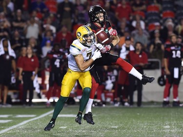 Eskimos defensive back Josh Woodman (7) breaks up a pass intended for Redblacks wide receiver Greg Ellingson (82) during second-half action. THE CANADIAN PRESS/Sean Kilpatrick