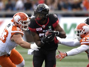 The Ottawa Redblacks' Mossis Madu, who had a two-touchdown game, runs the ball past the B.C. Lions' Crag Roh (93) and Anthony Gaitor during the first half at TD Place on Saturday, Aug. 26, 2017.