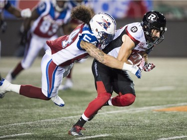 Redblacks slotback Brad Sinopoli is tackled by Alouettes linebacker Anthony Sarao during the first quarter in Montreal on Thursday night. THE CANADIAN PRESS/Paul Chiasson